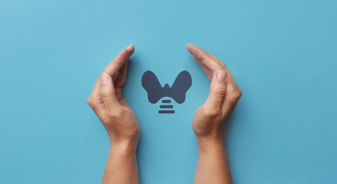 Hands cupped around a butterfly-shaped thyroid gland symbol on a blue background, representing thyroid health