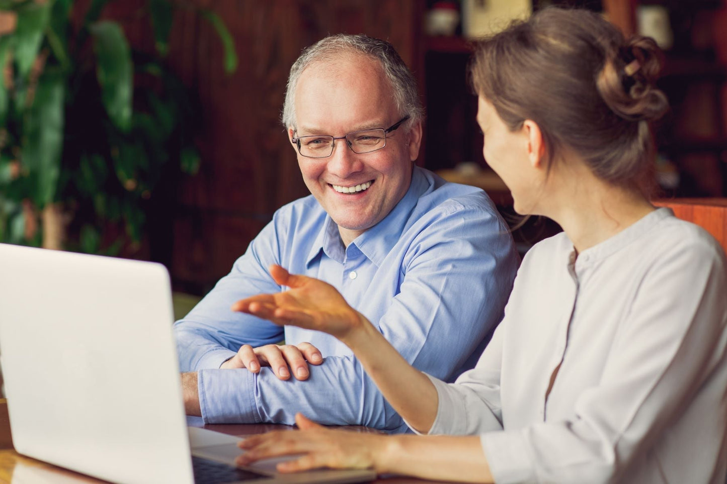 Older couple smiling at a laptop together, representing learning the facts behind common bone health myths