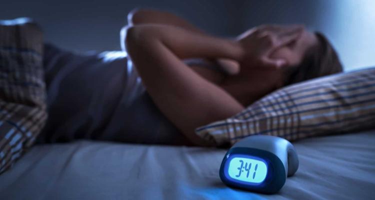 Person lying awake in bed at night beside a clock reading 3:41, representing sleeplessness and sleep aids