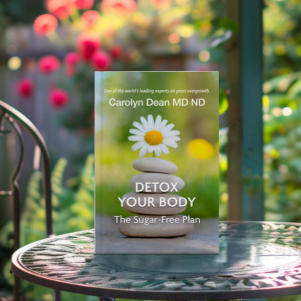 Detox Your Body: The Sugar-Free Plan by Carolyn Dean MD ND, book standing on a garden table among flowers