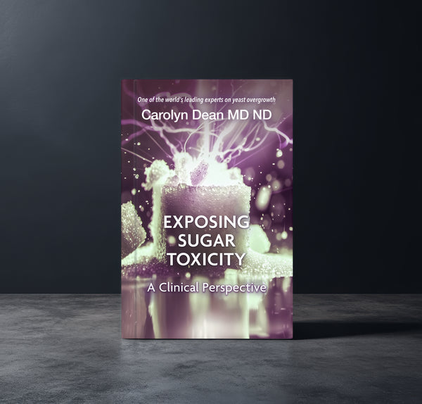 Exposing Sugar Toxicity: A Clinical Perspective by Carolyn Dean MD ND, book standing on a dark studio surface